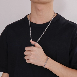 Close-up of polished silver stainless steel mariner link necklace and bracelet set on a model