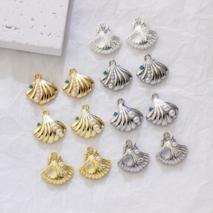 Detailed view of ocean shell charms in gold and silver with inlaid pearls and rhinestones