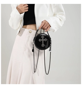 Detail of gothic black round crossbody bag with silver cross and metal chain