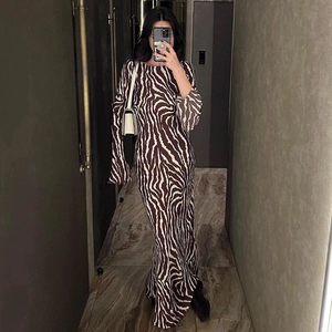 Detail of bohemian zebra print long sleeve dress with soft draping and floor length cut