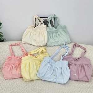 Detailed close-up of colorful pleated canvas tote bags with adjustable bow straps in soft macaron tones