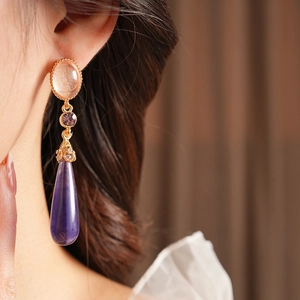 Gros plan de boucles d'oreilles vintage avec résine violette et cristaux brillants
