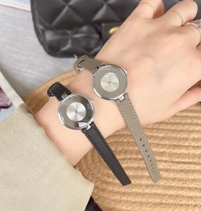 Close-up of minimalist women's watches with leather straps and silver round dials