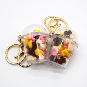 Detailed view of two miniature popcorn bucket keychains with colorful popcorn and gold rings