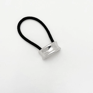 Macro shot of high-stretch black hair tie with polished silver metal u-shape accessory