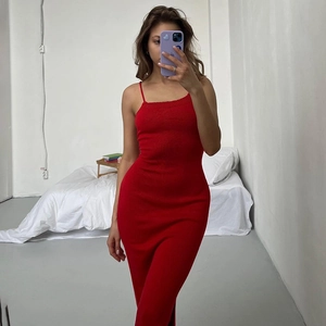 Détail d'une robe rouge en maille avec dos nu à lacets et fente latérale élégante