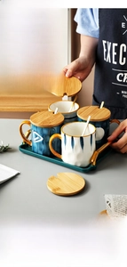 Close-up of ceramic mug with wooden lid featuring a spoon slot and a golden spoon