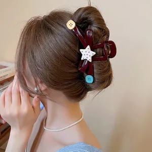 Dark red acrylic hair claw clip with colorful star and buttons on elegant updo hair
