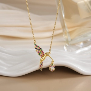 Macro detail of bird pendant with vibrant colorful zircon stones on golden chain