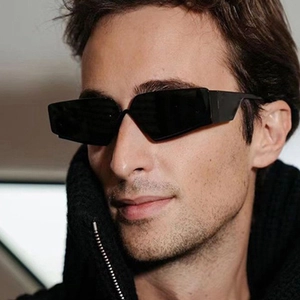 Futuristic Y2K rimless sunglasses with thick black frame worn by male model in side view