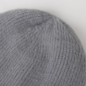 Close-up of grey knit beanie featuring soft fuzzy mohair texture and premium stitching