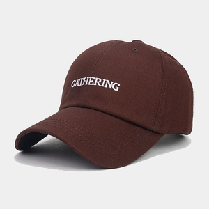 Detail of white GATHERING embroidery on dark brown cotton baseball cap fabric