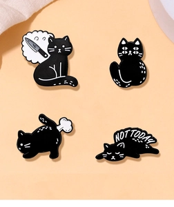 Détail de quatre épingles en émail chat noir avec motifs ludiques sur fond rose