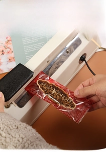 Handheld heat sealer sealing a decorative snack bag with a polished metal strip