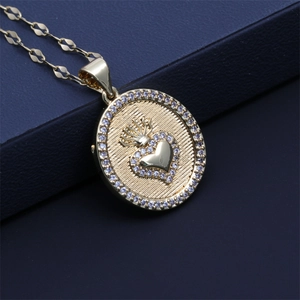 Macro shot of gold necklace featuring a round crown and heart pendant with zircon crystals