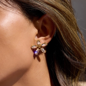 Gros plan de boucles d'oreilles fleur dorée avec cinq zircons marquise et centre brillant