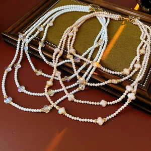 Vue détaillée de colliers de perles multicouches sur un cadre en bois de style vintage