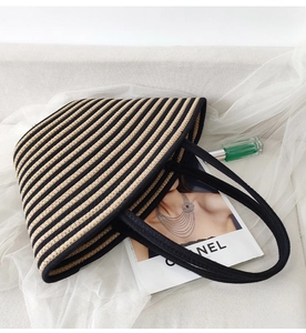 Top view of striped woven cotton rope tote bag with magazine and perfume on white fabric