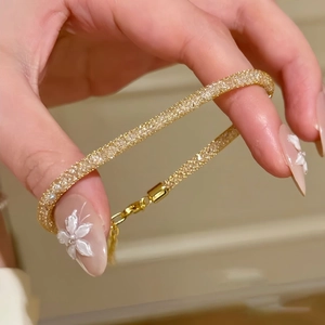 Detail of gold chain bracelet with sparkling pavé cubic zirconia on wrist