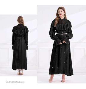 Détails de la robe plissée noire avec encolure en dentelle et ceinture perlée chic