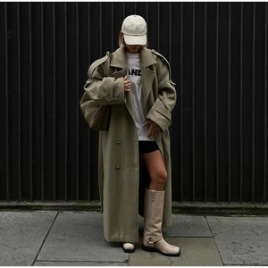 Detail of oversized wool coat in olive green with heavy fabric texture and street style