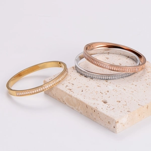 Three-color stainless steel bangles with baguette-cut zircon in a luxury display