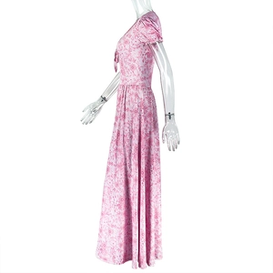 Détail d'une robe longue fleurie rose avec manches bouffantes et col en V élégant de profil