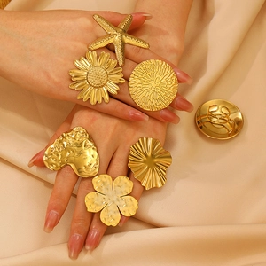 Gold stainless steel rings with flower starfish heart shapes on champagne silk fabric