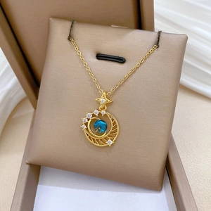 Star and moon necklace in gold with blue gemstone and diamonds on silk background