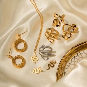 Elegant 18K gold plated stainless steel snake jewelry set displayed on soft silk fabric