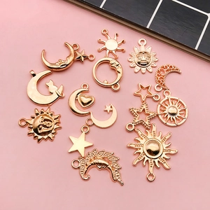 Detailed view of assorted gold alloy moon, sun, and star charms for DIY jewelry making