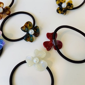 Detail of floral hair ties with resin petals and pearls in burgundy and tortoiseshell