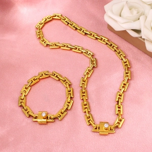 Gold H-link necklace and bracelet set with cubic zirconia on pink silk fabric