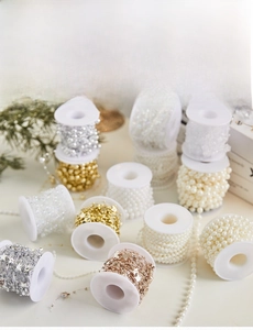 Detailed view of assorted Christmas pearl beads and star chains on white spools