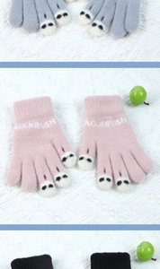 Detailed view of knitted gloves in gray, pink, and black with cute cartoon paw designs
