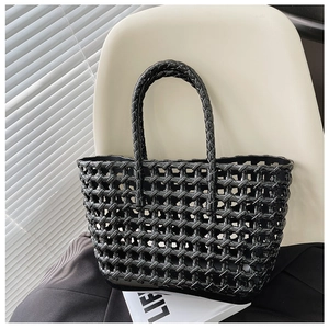 Detail of black woven hollow tote bag on a white modern chair by shutters
