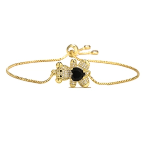 Detailed shot of golden bear charm bracelet with white zircons and black heart stone