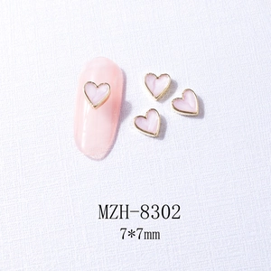 Detailed macro view of 7x7mm heart-shaped marble nail art charms with gold metal edges