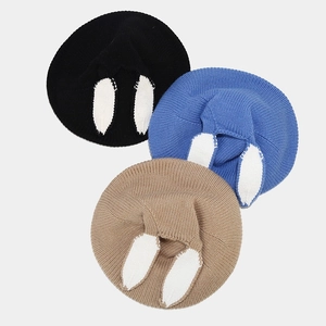 Detail of three knitted rabbit ear berets showing soft texture and kawaii animal design