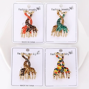 Detail of four colorful enamel giraffe brooches with gold-tone alloy textures and patterns