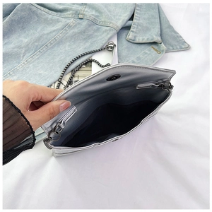 Detailed interior of silver chain evening bag showing black lining and magnetic closure