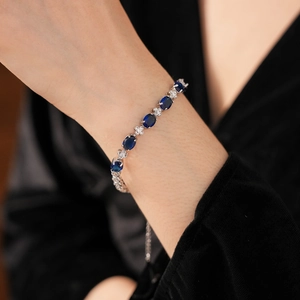 Detail of silver bracelet featuring oval dark blue gemstones and sparkling white zircons