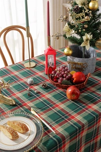 Detail of red and green plaid Christmas tablecloth with festive table setting decor