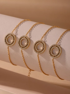 Detailed view of four gold-plated stainless steel necklaces with sparkling diamond double rings