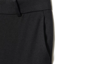 Detailed macro view of woven black fabric texture and side pocket construction on trousers