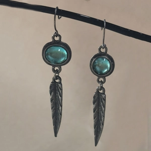 Vintage bohemian drop earrings featuring translucent blue stones and silver feather pendants