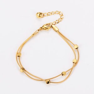 Detail view of gold double-layer snake chain bracelet with cubes and lobster clasp