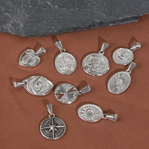 Macro shot of assorted vintage stainless steel religious pendants on textured surface