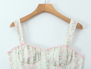Dettaglio dell'abito floreale rosa con bordo in pizzo e design del busto a pieghe