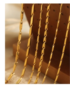 Detailed view of luxury gold-tone stainless steel necklaces with geometric bamboo texture